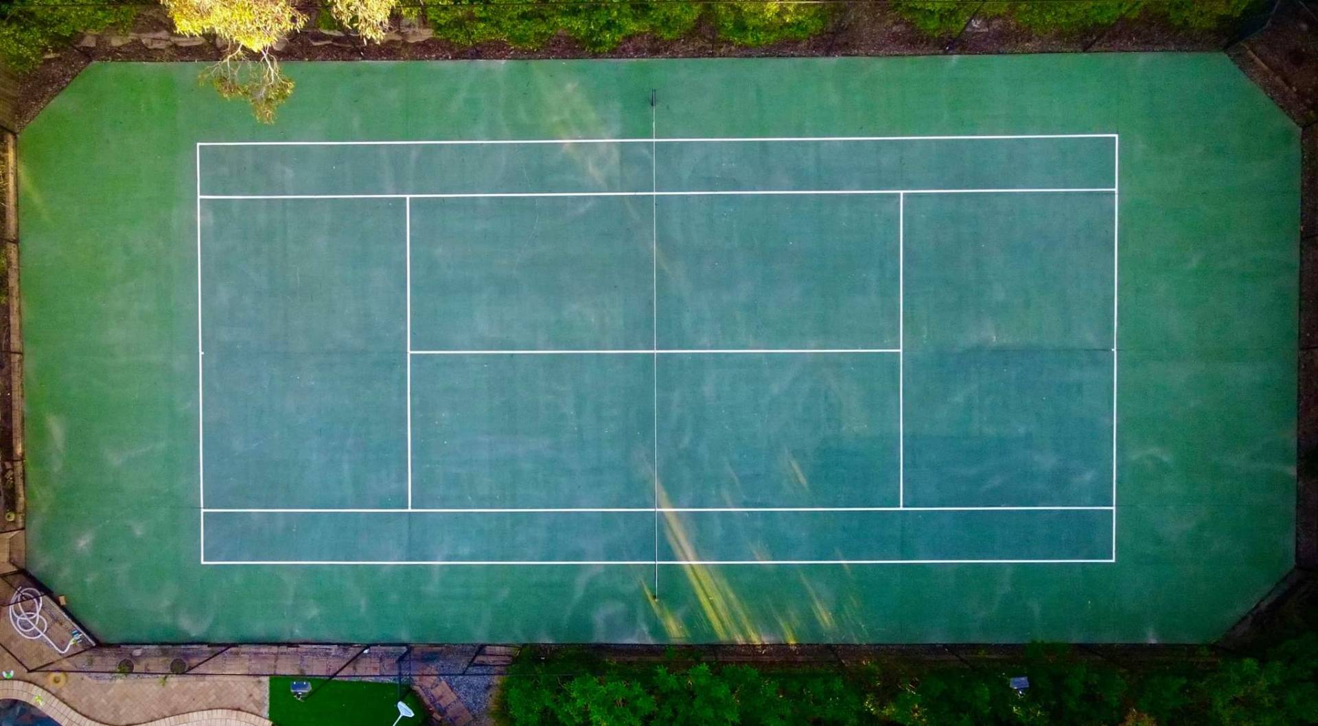 Aerial view of fully cleaned tennis court after professional pressure washing — South East Queensland
