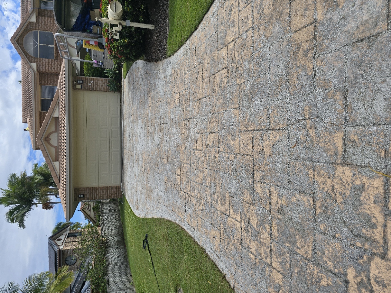 Decorative stamped concrete driveway before cleaning and sealing — faded and worn on Brisbane property