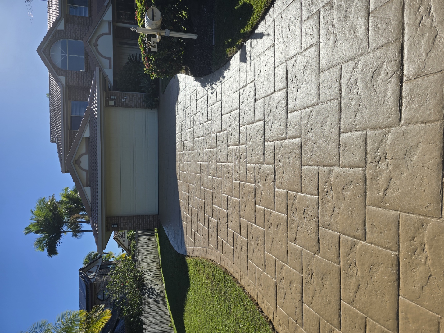 Same decorative stamped concrete driveway after professional cleaning and colour sealing — Brisbane