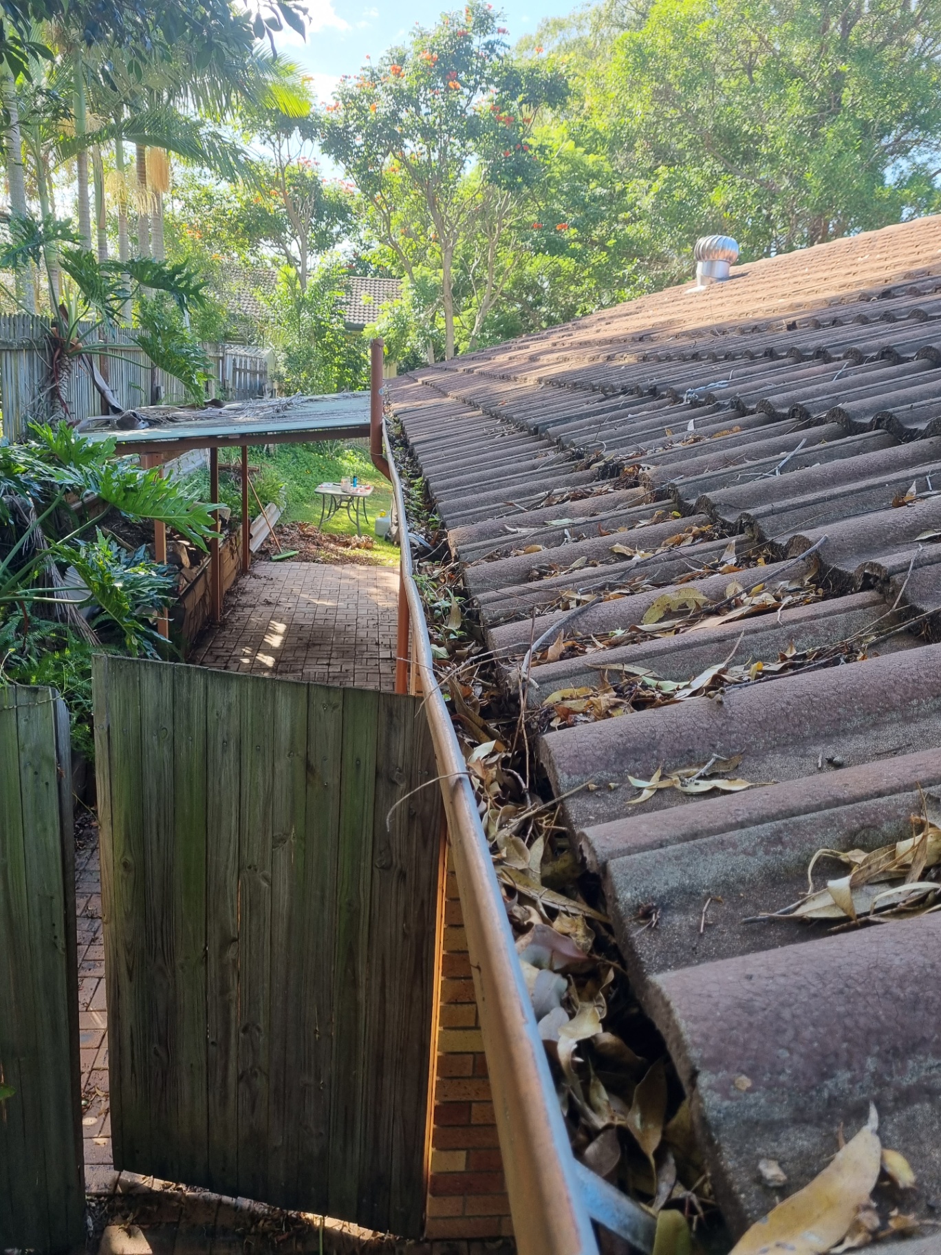 Gutters completely blocked with leaves and debris on a South East Queensland home — a clear sign gutter guard is needed